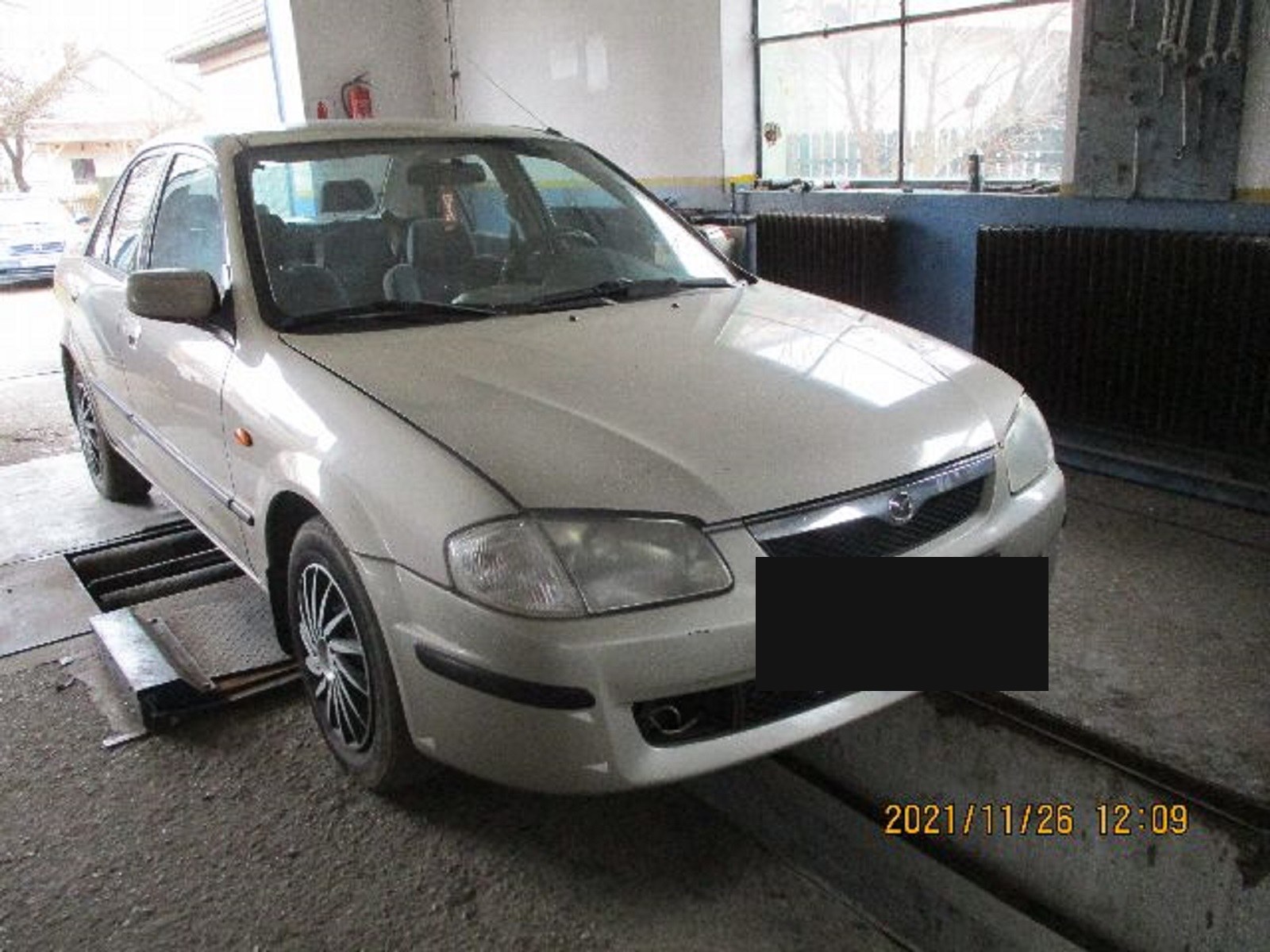A szerelmi ajándék: 1999-es Mazda 323, tizenhat korábbi tulajdonossal. A felvétel 2021 novemberében készült, néhány héttel a vásárlás előtt. A rendszámot kitakartuk.